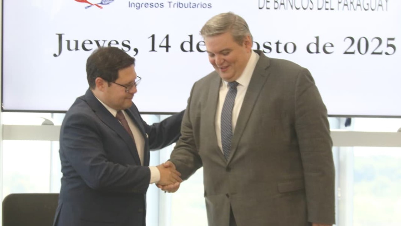 Óscar Orúe y Osvaldo Serafini se estrechan la mano luego de la firma