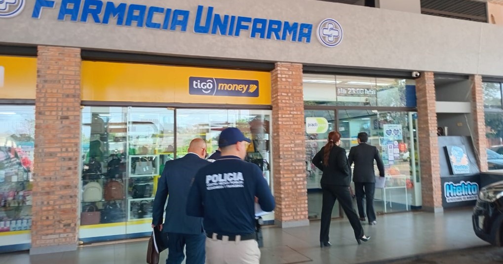 Agentes de la DNIT acompañados por la Policia Nacional ingresan a la Farmacia.